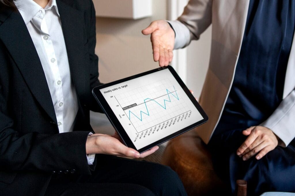 gestores analisando o track record de uma empresa através de um tablet