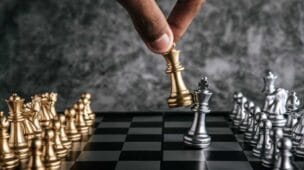 gestor jogando xadrez e derrubando o adversário, representando um estratégia de negócios